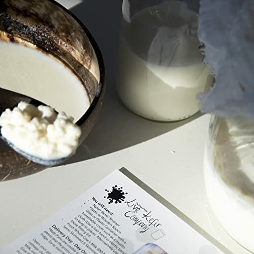 Kefir grains and glass jar on a table with instructions.