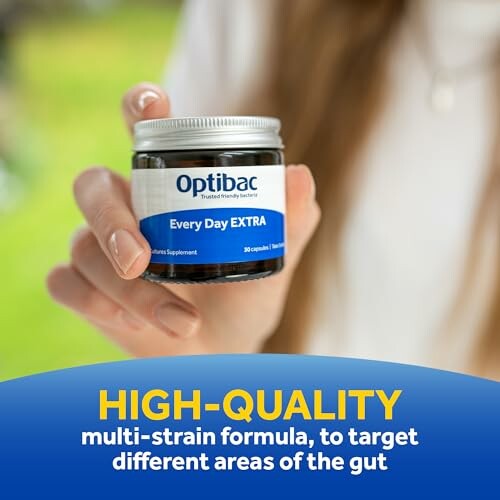 Optibac Every Day Extra supplement jar held by a person.