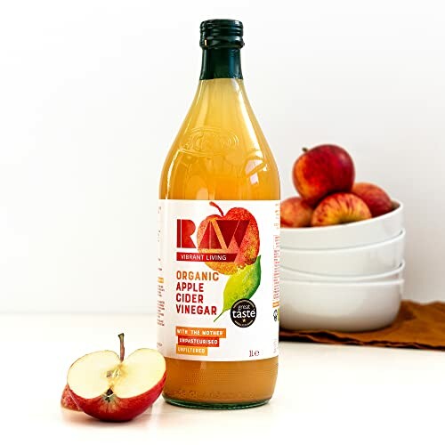 Organic apple cider vinegar bottle with apples in background