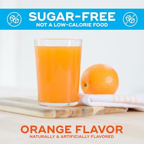 Glass of sugar-free orange flavored drink with an orange on a wooden board.